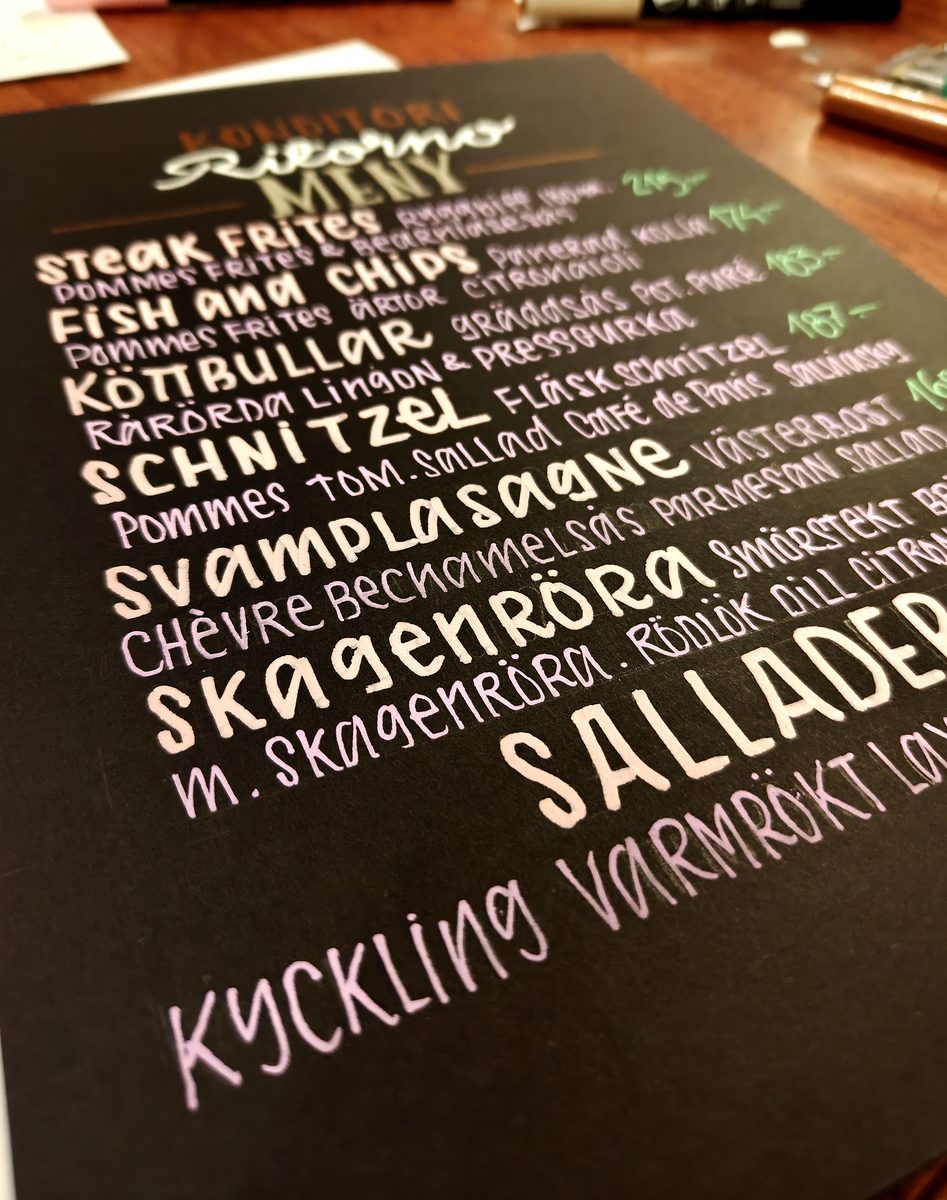 Close-up of a hand-lettered restaurant menu board