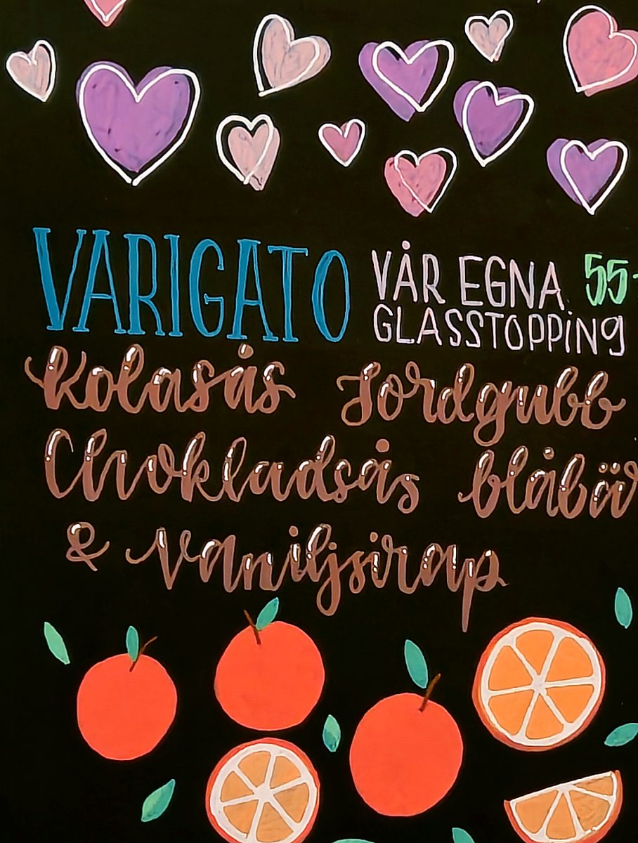 Hand-lettered blackboard menu with hearts and orange illustrations